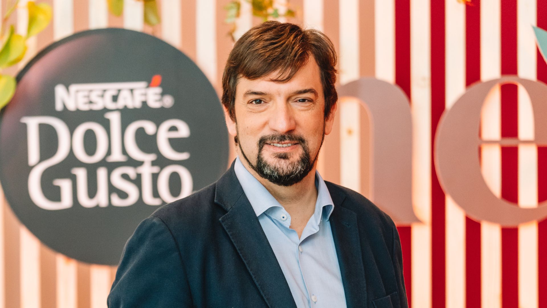 Em março de 2024, a Nestlé lançou em Portugal o sistema NEO, a nova geração de máquinas de café em cápsulas de NESCAFÉ Dolce Gusto. Este lançamento representa um marco significativo na experiência de café em casa, trazendo uma tecnologia inovadora que transforma a forma como os consumidores desfrutam do seu café todos os dias. NEO desafiou o status quo, provando que a tecnologia e a sustentabilidade são a chave para conquistar um consumidor apaixonado por café, sedento por novidades, mas preocupado com o futuro. Baseado na revolucionária tecnologia SmartBrew, NEO é o primeiro sistema de café em cápsulas que ajusta automaticamente vários parâmetros de extração, recriando as técnicas de um barista. Com um simples toque de um botão, os consumidores podem escolher entre três métodos de extração: Alta Pressão para preparar expressos, ristrettos e lungos; Top Up para verdadeiros americanos; e Slow Brew para cafés tipo filtro. Esta versatilidade, combinada com um design inovador, torna NEO indispensável a qualquer casa. Outro fator que mais distingue NEO é o seu compromisso com a sustentabilidade. Em linha com a nossa meta de reduzir a utilização de plásticos virgens em um terço até este ano, as novas cápsulas de café NEO são feitas à base de papel e compostáveis, tanto a nível doméstico como industrial. O sistema NEO foi lançado especificamente para atender às preocupações ambientais latentes, com uma máquina com design sustentável: 50 % plástico reciclado, termobloco com 85% de alumínio reciclado, concebida para ser facilmente desmontada e com uma garantia de reparação até 15 anos, refletindo o nosso compromisso com a economia circular. Em resumo, o NEO é a combinação perfeita entre a qualidade superior de um café de coffee shop, a personalização e a responsabilidade ambiental. Convidamos todos a experimentar o futuro do café em casa, onde cada chávena não é apenas uma pausa, mas um passo em direção a um futuro mais sustentável. Miguel Abreu, Marketing Manager da NESCAFÉ Dolce Gusto